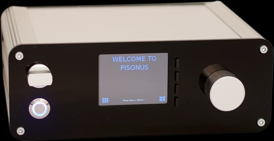 The first PISONUS, 2016: an aluminium case with a black front, a small touchscreen saying “Welcome to PISONUS”, a power button and a volume knob